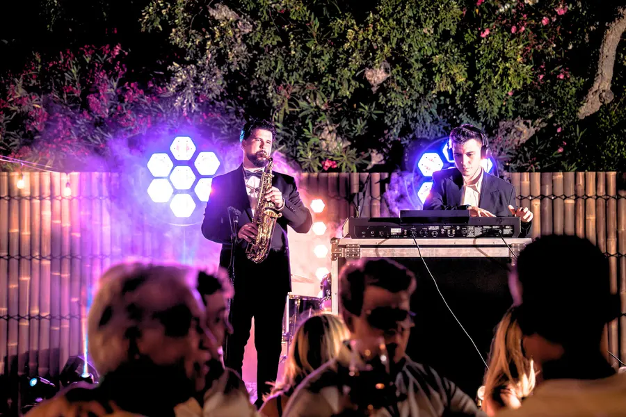 DJ with live saxophone at night