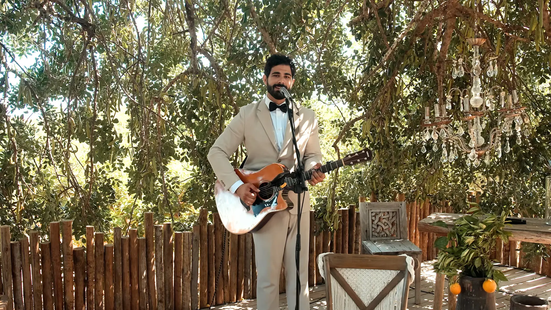 Guitarist performing in a garden setting