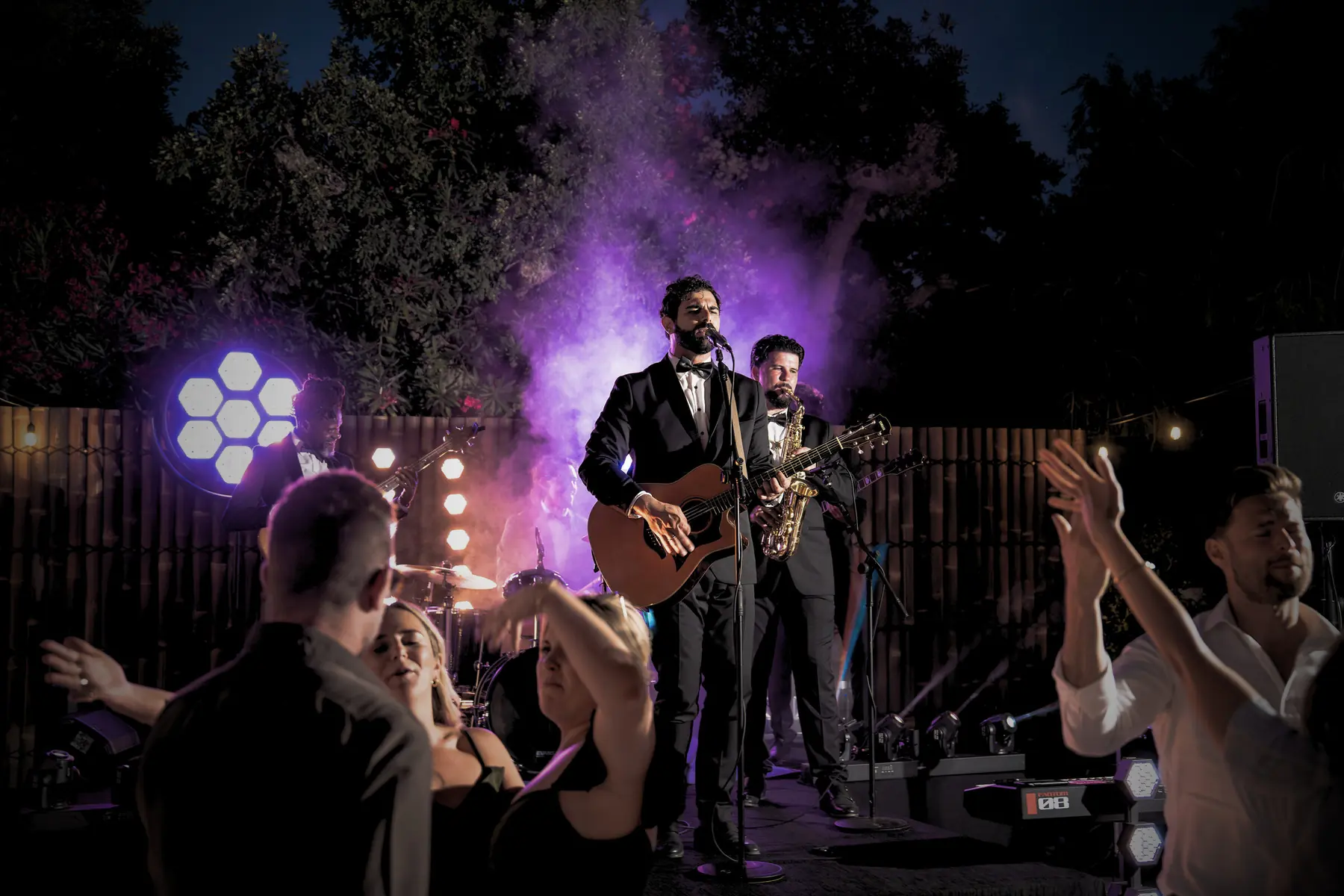 Concert lighting and haze over the band at night