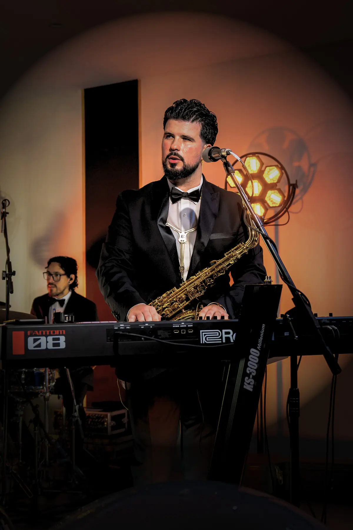 Retro stage lights framing a saxophonist and keyboard