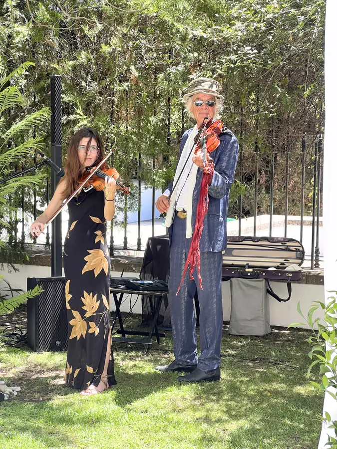 String duo playing in a garden