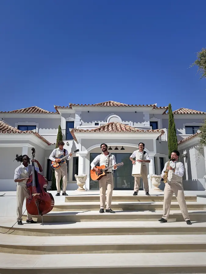 Musicians on the steps of a white villa