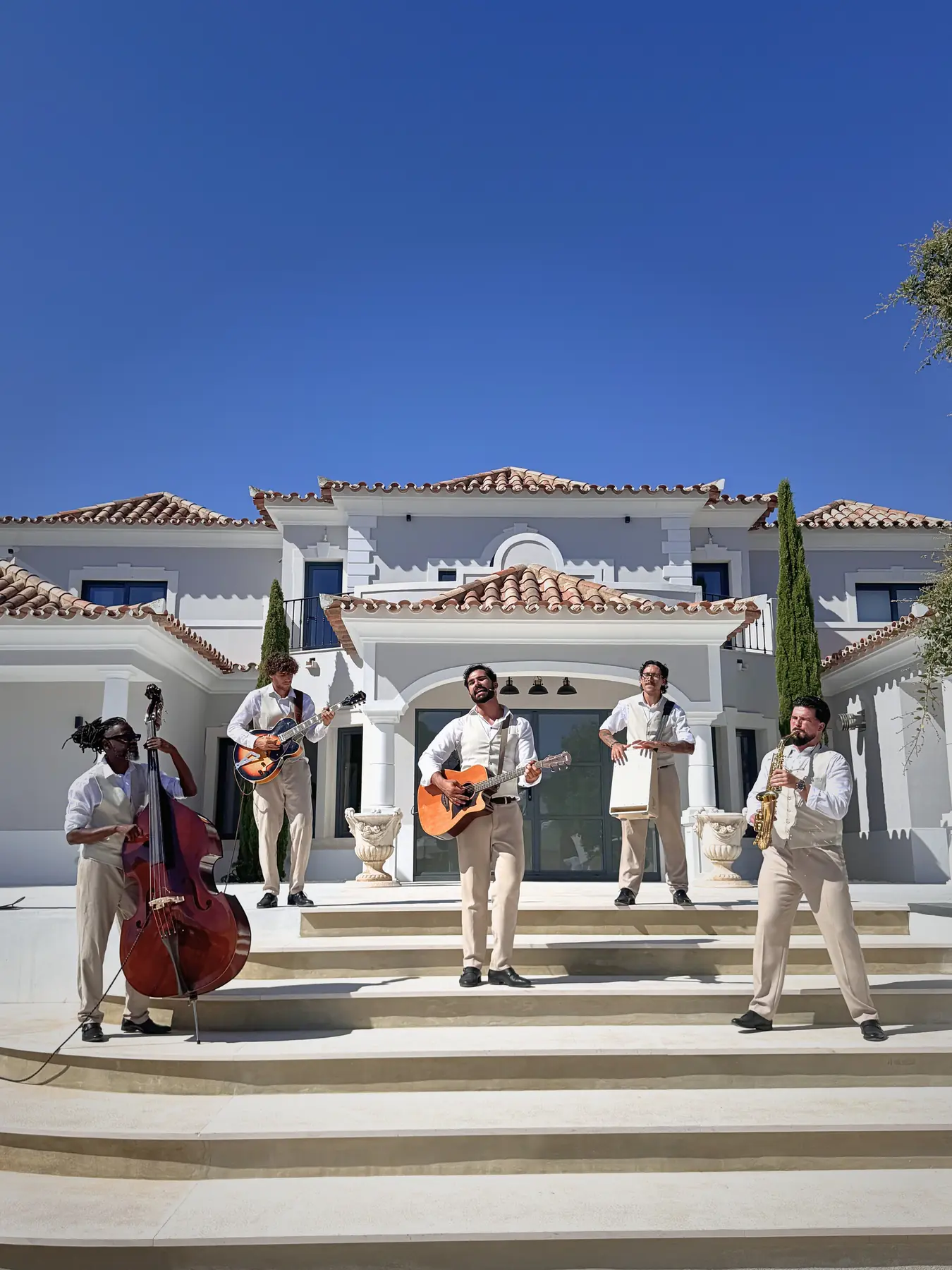 The Keys musicians on the steps of a white villa